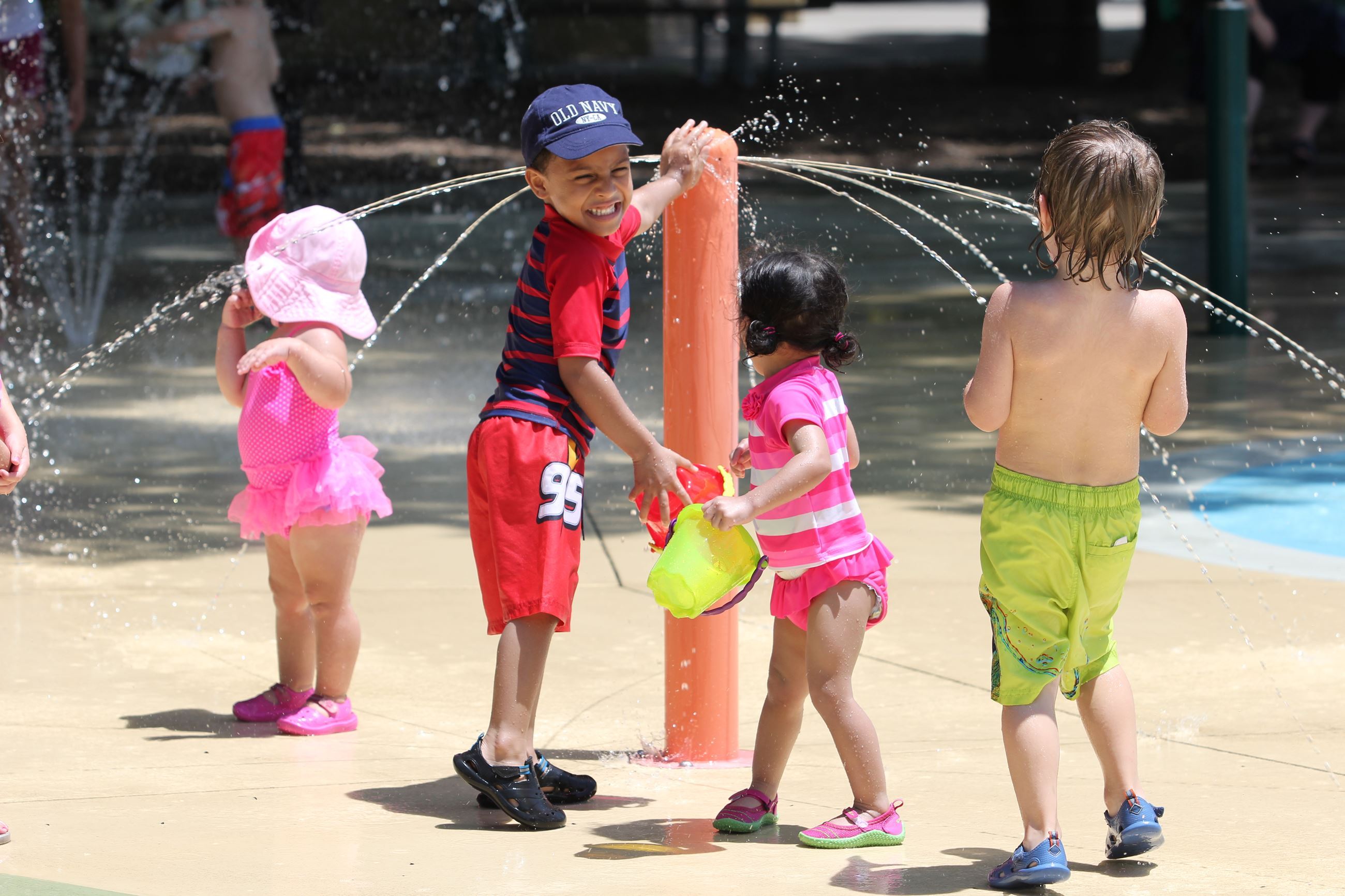Kids playing by sprinkler
