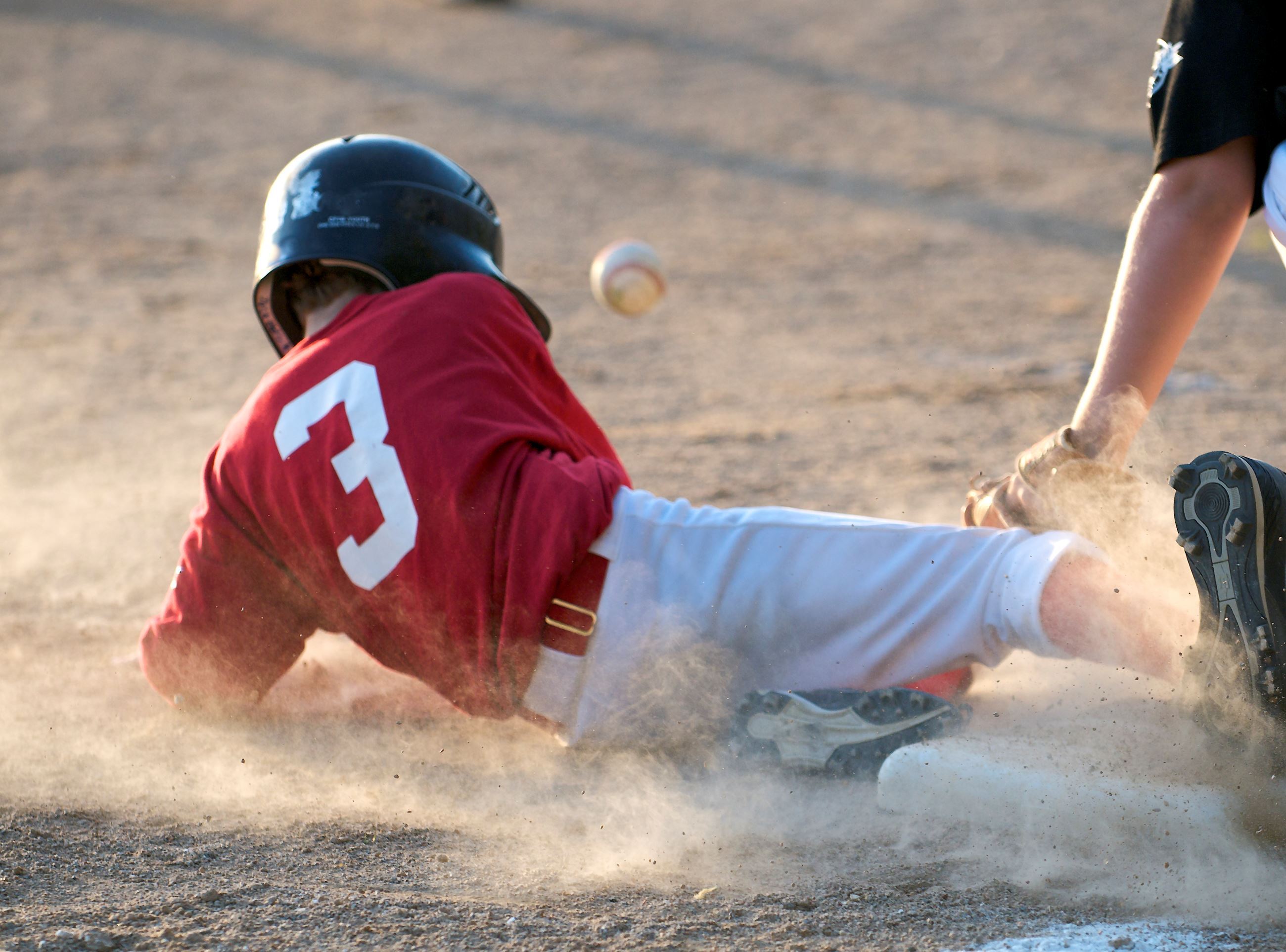 Baseball player sliding into a base